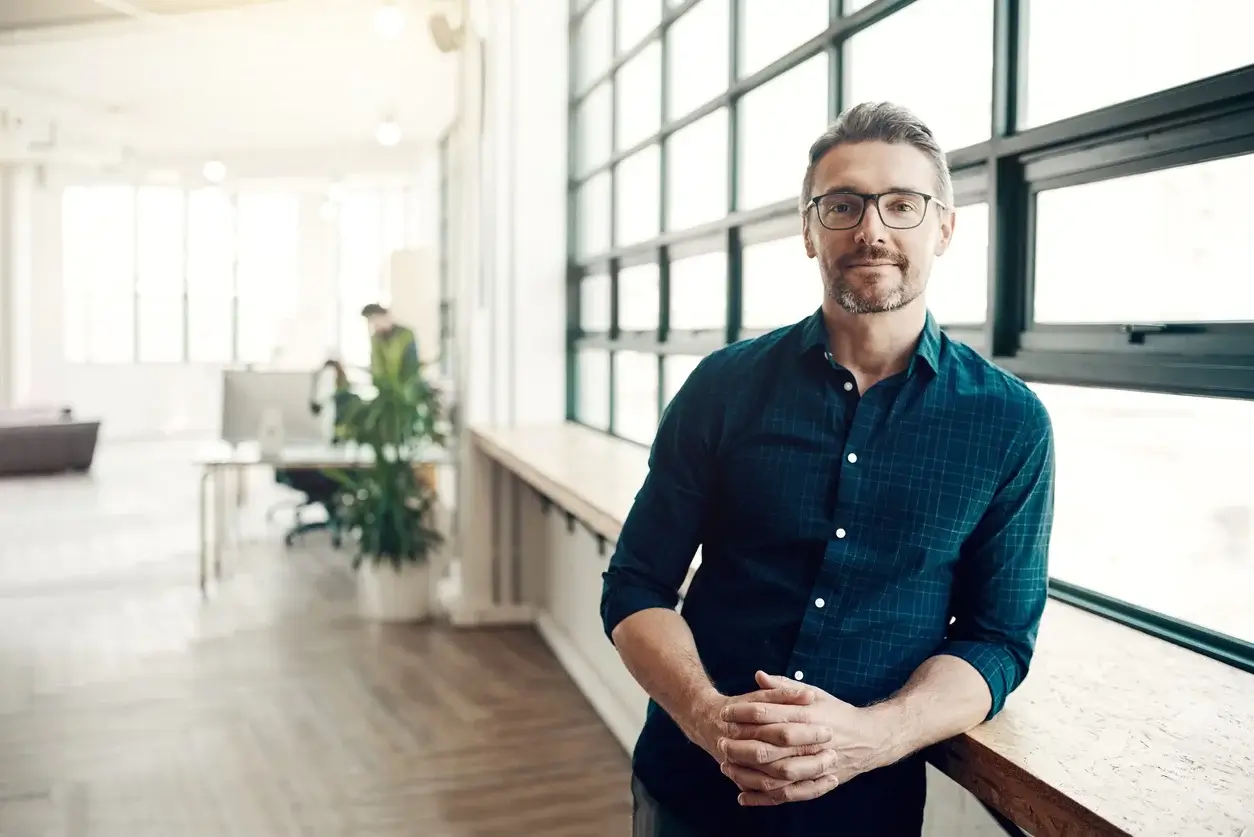 A man standing with his elbow on a counter