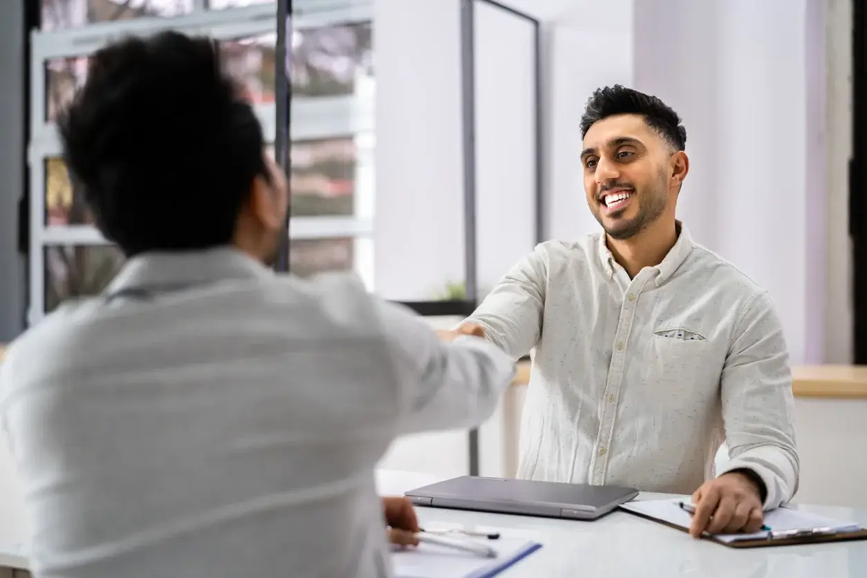 Two men shaking hands at a table
